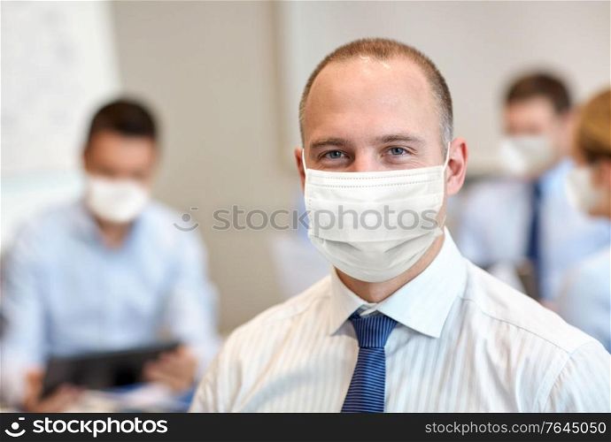 business, people and pandemic concept - businessman wearing face protective medical mask for protection from virus disease at office. businessman wearing face protective mask at office
