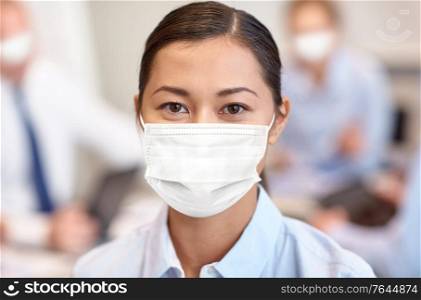 business, people and pandemic concept - businesswoman wearing face protective medical mask for protection from virus disease at office. businesswoman in face protective mask at office
