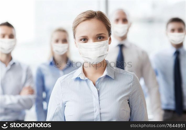 business, people and pandemic concept - businesswoman wearing face protective medical mask for protection from virus disease with group of businesspeople in office. businesswoman in mask with colleagues in office