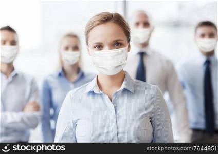 business, people and pandemic concept - businesswoman wearing face protective medical mask for protection from virus disease with group of businesspeople in office. businesswoman in mask with colleagues in office