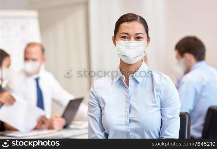business, people and pandemic concept - businesswoman wearing face protective medical mask for protection from virus disease at office. businesswoman in face protective mask at office