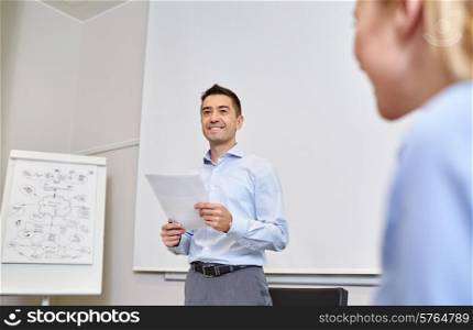 business, people and planning concept - smiling businessman and woman with papers meeting on presentation in office