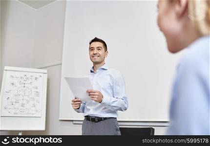 business, people and planning concept - smiling businessman and woman with papers meeting on presentation in office