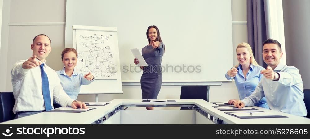 business, people and teamwork concept - group of smiling businesspeople meeting and pointing finger at you in office