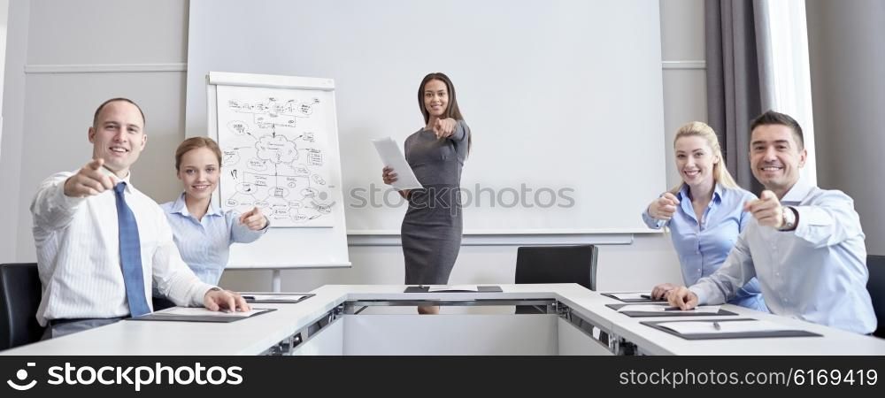 business, people and teamwork concept - group of smiling businesspeople meeting and pointing finger at you in office