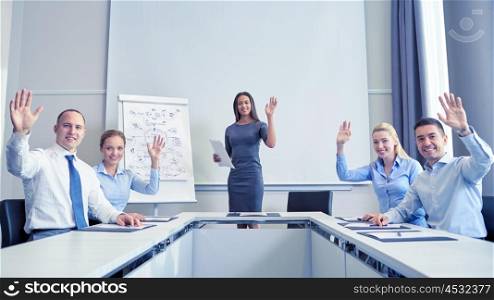 business, people and teamwork concept - group of smiling businesspeople meeting and waving hands in office