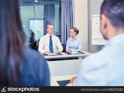 business, people and teamwork concept - group of smiling businesspeople meeting in office