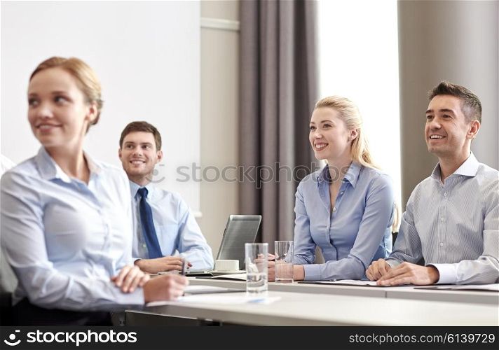 business, people and teamwork concept - group of smiling businesspeople meeting on presentation in office