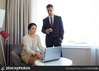 business, people and teamwork concept - man and woman with laptop computer and smartphone working at hotel room. business team with laptop working at hotel room