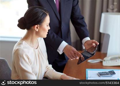 business, people and teamwork concept - man and woman with tablet pc computer working at hotel room. business team with tablet pc working at hotel room