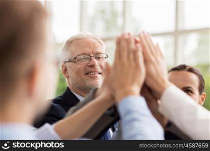 business, people and teamwork concept - smiling business people making high five in office