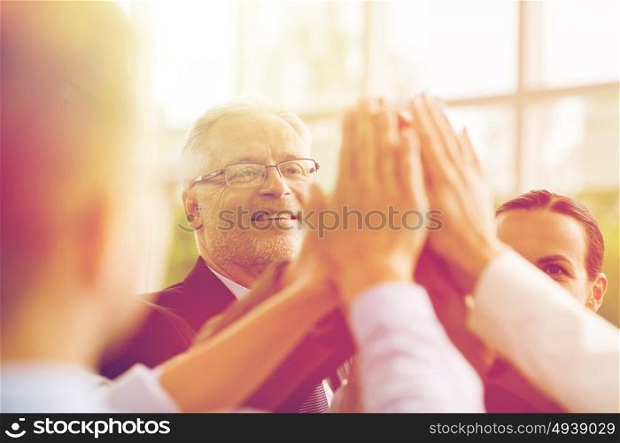 business, people and teamwork concept - smiling business people making high five in office. business people making high five in office