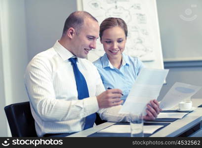 business, people and teamwork concept - smiling business team with papers meeting in office