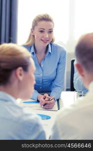 business, people and teamwork concept - smiling business team with papers meeting in office