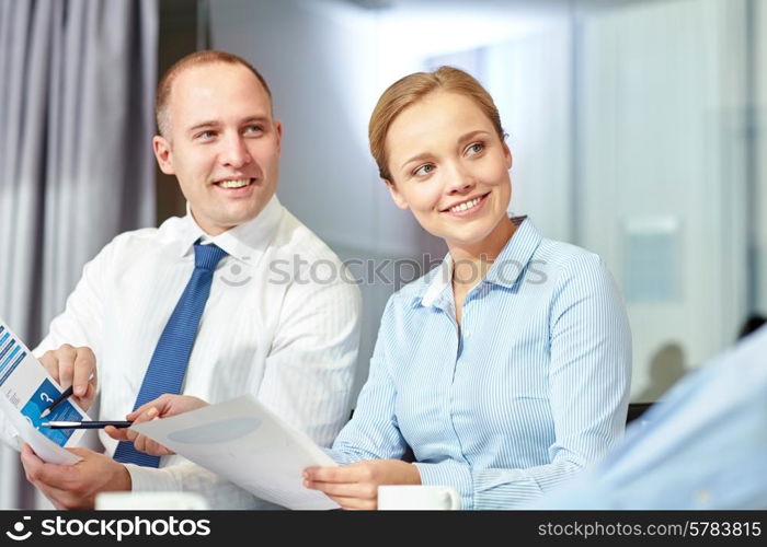 business, people and teamwork concept - smiling business team with papers meeting in office