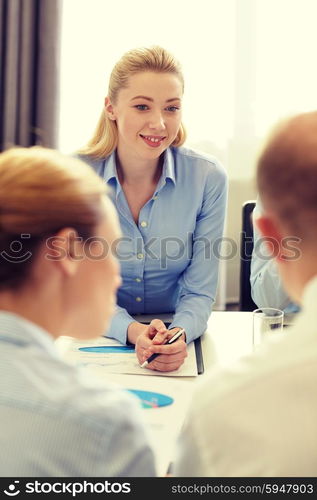 business, people and teamwork concept - smiling business team with papers meeting in office