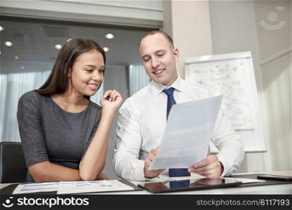 business, people and teamwork concept - smiling businessman and businesswoman with papers meeting in office