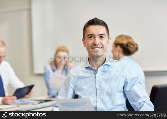 business, people and teamwork concept - smiling businessman with group of businesspeople meeting in office