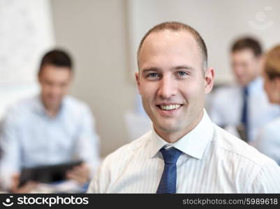 business, people and teamwork concept - smiling businessman with group of businesspeople meeting in office