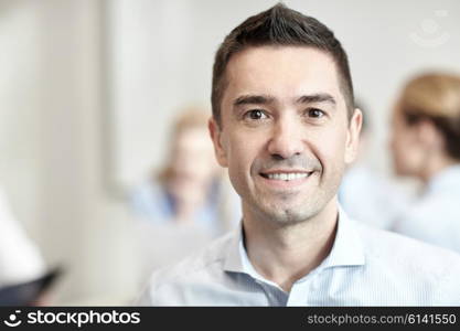 business, people and teamwork concept - smiling businessman with group of businesspeople meeting in office