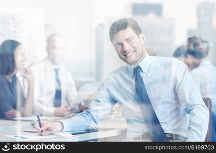 business, people and teamwork concept - smiling businessman with group of businesspeople meeting in office