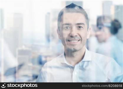 business, people and teamwork concept - smiling businessman with group of businesspeople meeting in office