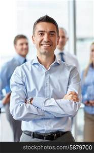 business, people and teamwork concept - smiling businessman with group of colleagues in office