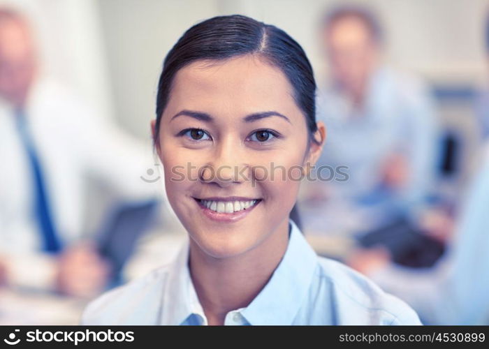 business, people and teamwork concept - smiling businesswoman with group of businesspeople meeting in office