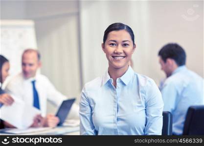 business, people and teamwork concept - smiling businesswoman with group of businesspeople meeting in office
