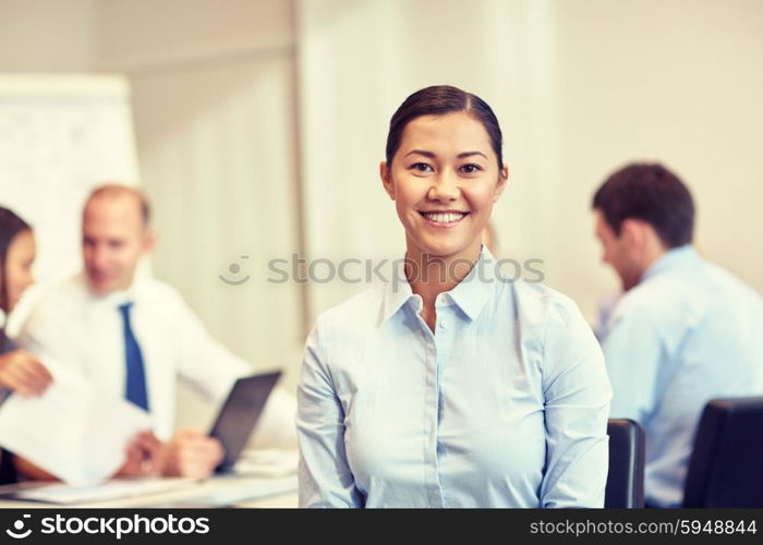 business, people and teamwork concept - smiling businesswoman with group of businesspeople meeting in office