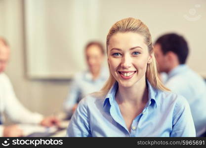 business, people and teamwork concept - smiling businesswoman with group of businesspeople meeting in office