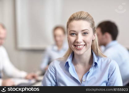 business, people and teamwork concept - smiling businesswoman with group of businesspeople meeting in office