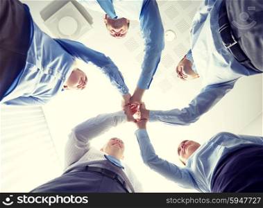 business, people and teamwork concept - smiling group of businesspeople standing in circle and making high five gesture
