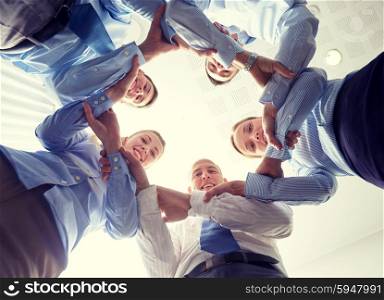 business, people and teamwork concept - smiling group of businesspeople standing in circle and holding to each other hands