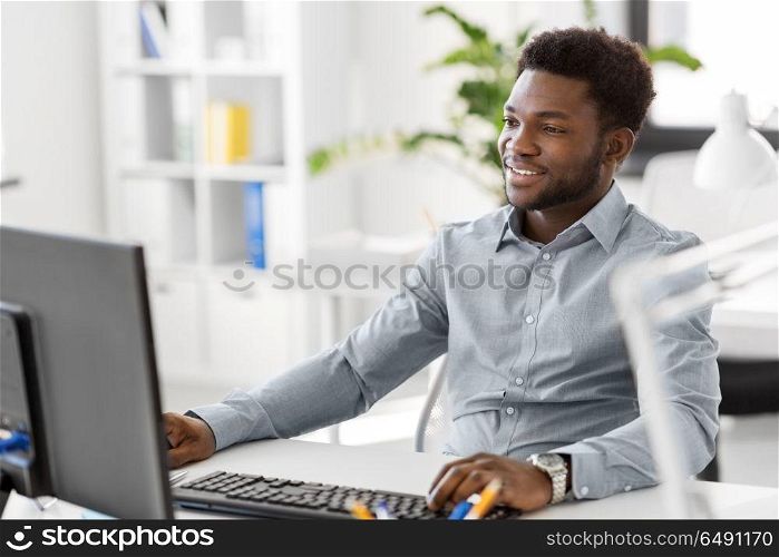 business, people and technology concept - african american businessman with computer working at office. african businessman with computer at office. african businessman with computer at office