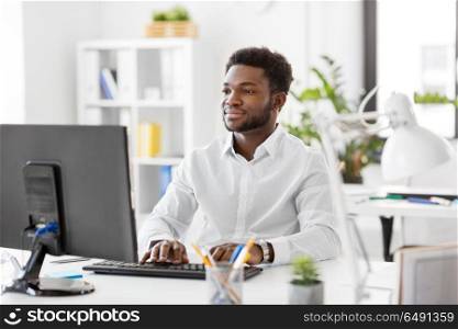 business, people and technology concept - african american businessman with computer working at office. african businessman with computer at office. african businessman with computer at office