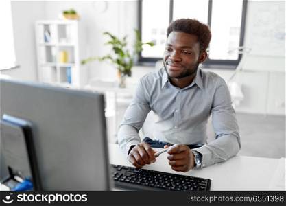 business, people and technology concept - african american businessman with computer working at office. african businessman works with computer at office. african businessman works with computer at office