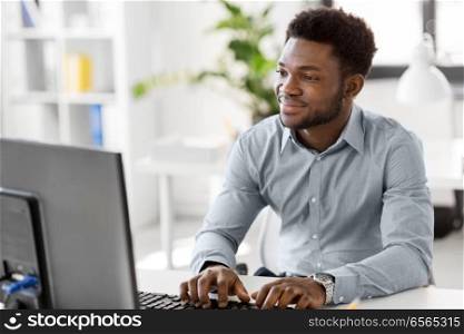 business, people and technology concept - african american businessman with computer working at office. african businessman with computer at office