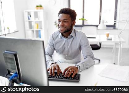 business, people and technology concept - african american businessman with computer working at office. african businessman works with computer at office. african businessman works with computer at office