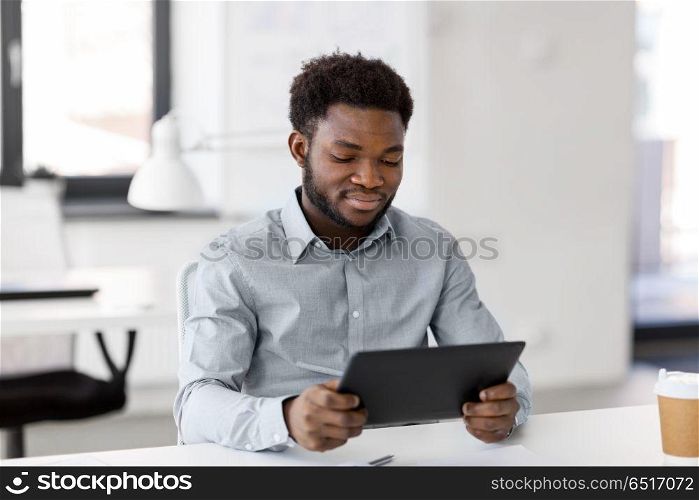 business, people and technology concept - african american businessman with tablet pc computer at office. smiling businessman with tablet pc at office. smiling businessman with tablet pc at office