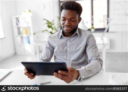 business, people and technology concept - african american businessman with tablet pc computer at office. african businessman with tablet pc at office