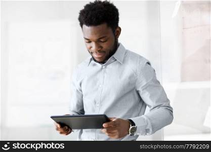 business, people and technology concept - african american businessman with tablet pc computer at office. smiling businessman with tablet pc at office
