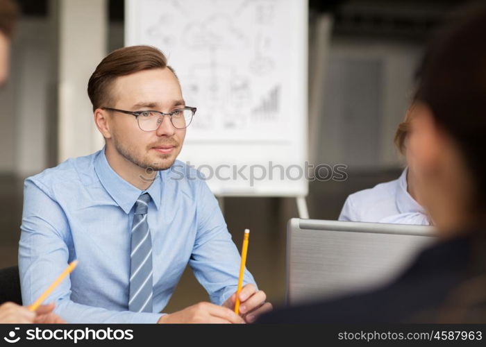 business, people and technology concept - business team with laptop computer meeting in office