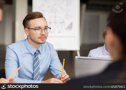 business, people and technology concept - business team with laptop computer meeting in office