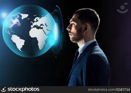 business, people and technology concept - businessman in suit looking at virtual earth projection over black background. businessman looking at virtual earth projection