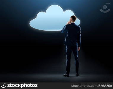 business, people and technology concept - businessman in suit looking at virtual cloud hologram over black background. businessman looking at virtual cloud hologram