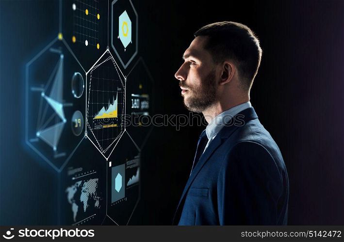 business, people and technology concept - businessman in suit looking at virtual projection over black background. businessman in suit looking at virtual projection