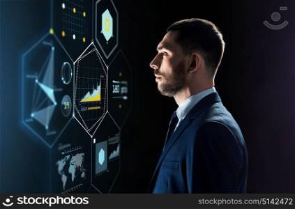 business, people and technology concept - businessman in suit looking at virtual projection over black background. businessman in suit looking at virtual projection