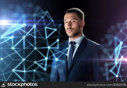 business, people and technology concept - businessman in suit over black background with low poly shape projection. businessman in suit over black