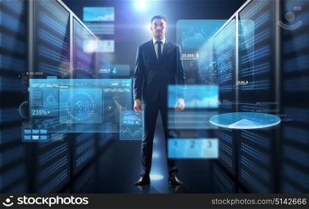 business, people and technology concept - businessman in suit with charts on virtual screen over server room background. businessman with charts on virtual screen